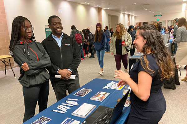 College Promise Scholar Night - people talking at booth